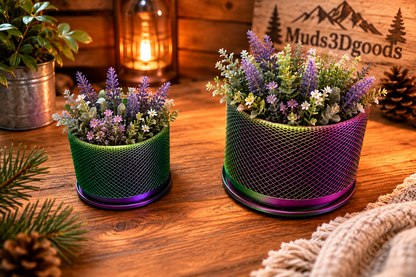 Two mesh planters with flowers on a wooden surface, featuring 'Muds3Dgoods' branding.
